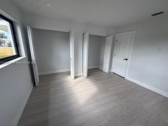 unfurnished room with wood-type flooring