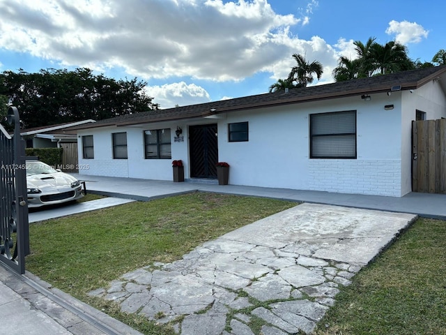 single story home with a front yard and a patio area