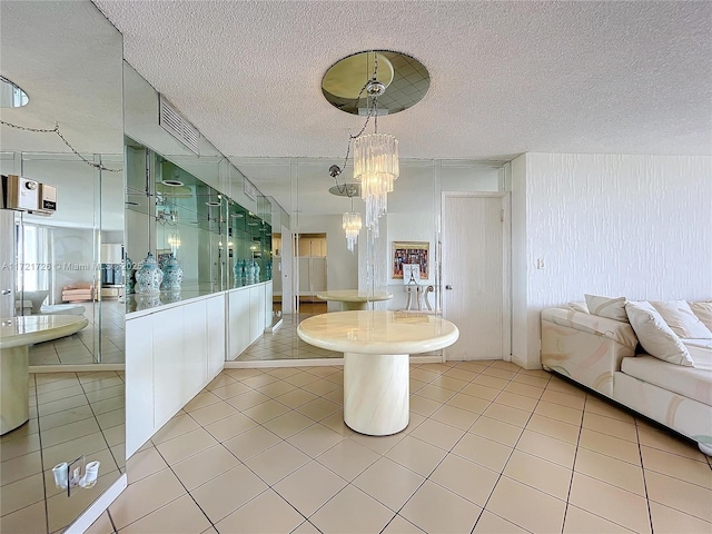 interior space featuring a textured ceiling, tile patterned floors, and an inviting chandelier