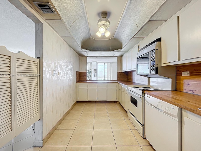 kitchen featuring light tile patterned flooring, white cabinetry, and dishwasher