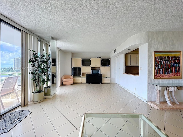 living room with a textured ceiling and light tile patterned floors