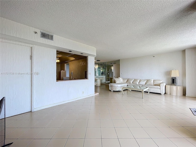 unfurnished living room with a textured ceiling and tile patterned floors