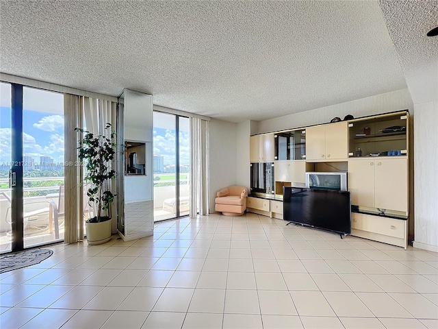 unfurnished living room with a wall of windows and light tile patterned floors