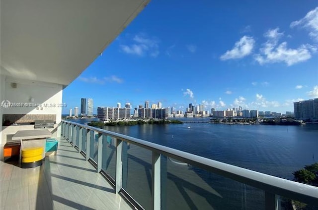 balcony with a water view and a grill