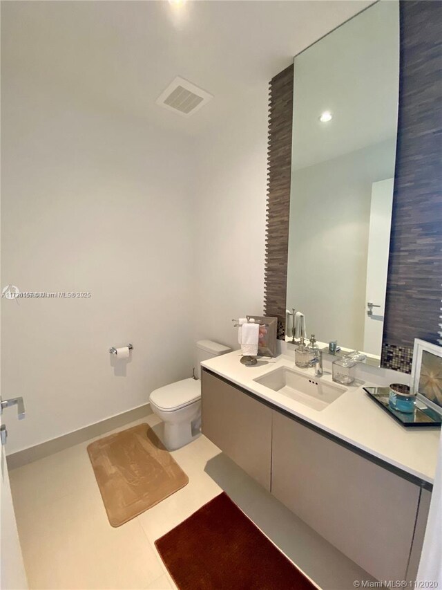 bathroom featuring toilet, vanity, and tile patterned floors