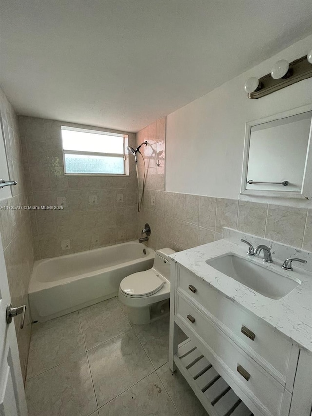 full bathroom featuring tile patterned flooring, tile walls, toilet, vanity, and tiled shower / bath combo