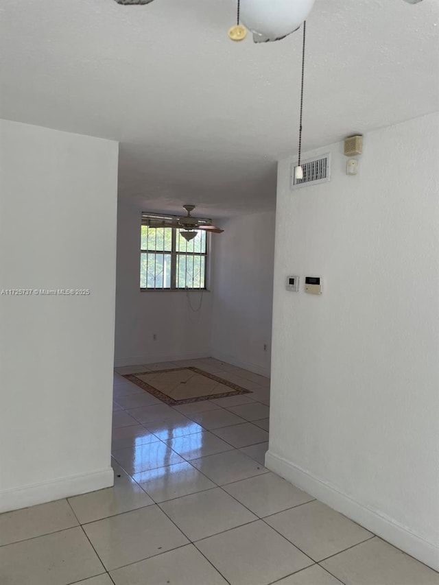 spare room featuring ceiling fan and light tile patterned floors