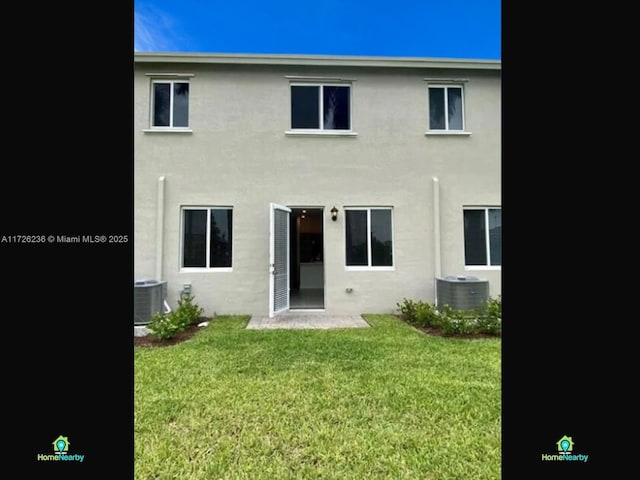 back of house featuring a lawn and central AC unit