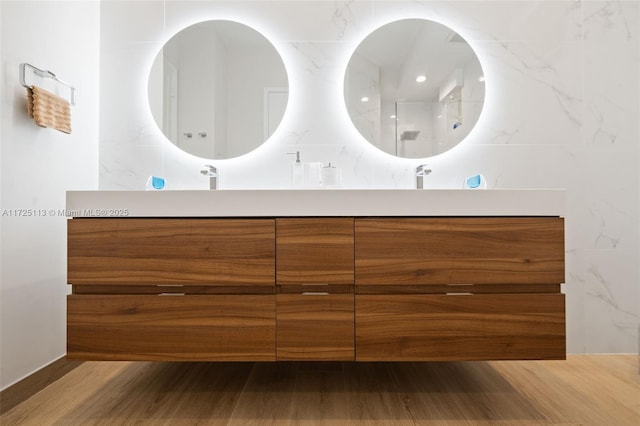 bathroom with a shower, wood-type flooring, and vanity