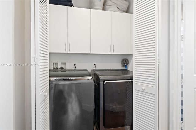 washroom featuring washing machine and clothes dryer and cabinets