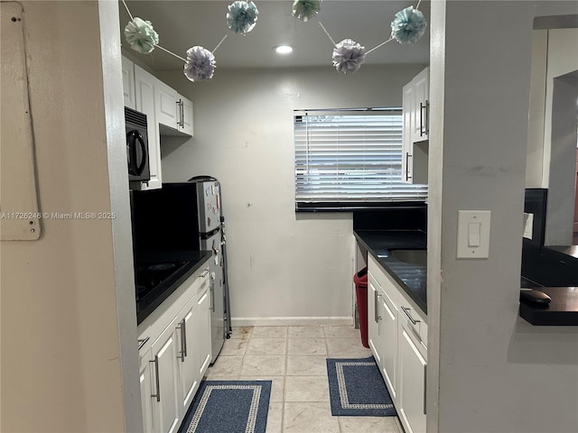 kitchen with white cabinetry, light tile patterned floors, and black appliances