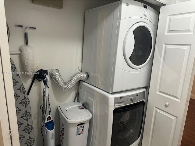 laundry room featuring wood-type flooring and stacked washer and clothes dryer