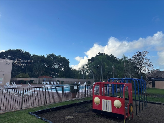 view of jungle gym featuring a community pool