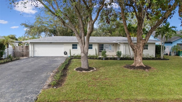 ranch-style house featuring a garage and a front lawn