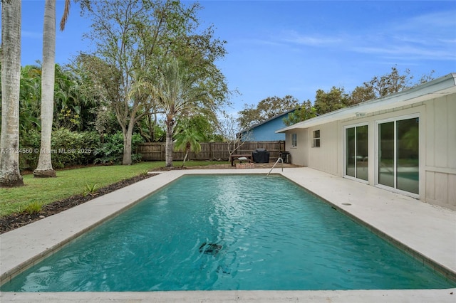 view of swimming pool with a patio and a yard