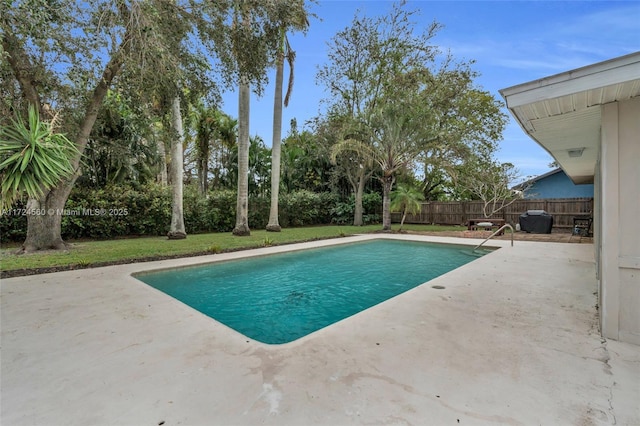 view of swimming pool with a patio area and a yard