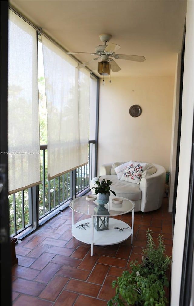 sunroom featuring ceiling fan and plenty of natural light