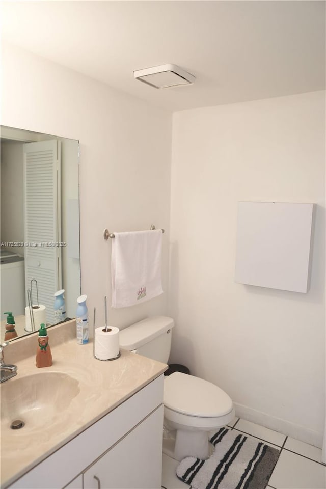 bathroom with toilet, tile patterned floors, and vanity