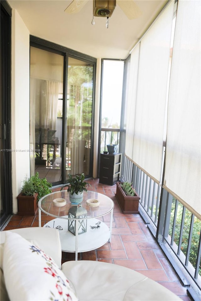 sunroom featuring ceiling fan and plenty of natural light