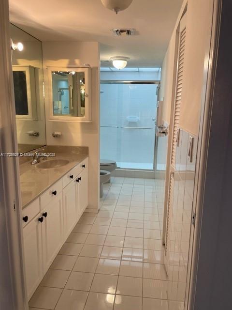 bathroom with vanity, tile patterned flooring, toilet, and walk in shower