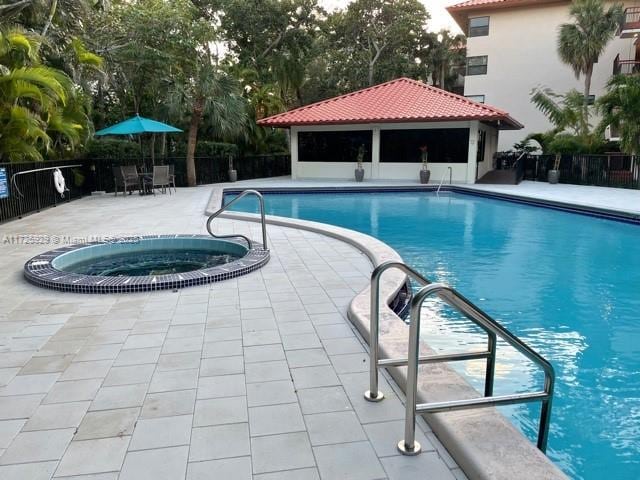 view of swimming pool featuring a gazebo, a community hot tub, and a patio area