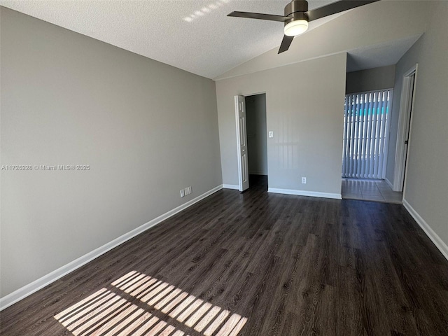 unfurnished room with lofted ceiling, a textured ceiling, ceiling fan, and dark hardwood / wood-style floors