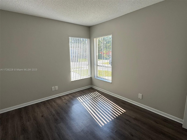 spare room with dark hardwood / wood-style flooring and a textured ceiling