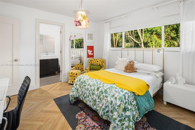 bedroom featuring light parquet flooring and ensuite bath