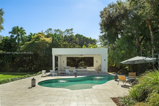 view of pool with ceiling fan, pool water feature, and a patio