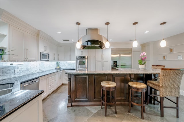 kitchen with hanging light fixtures, built in appliances, dark stone counters, a breakfast bar, and backsplash