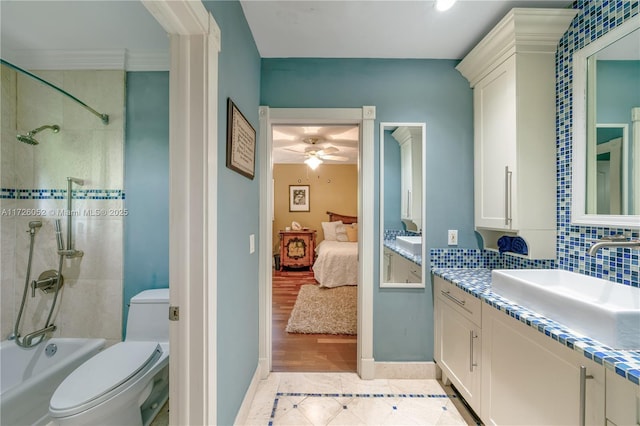 full bathroom with toilet, tub / shower combination, vanity, ceiling fan, and tasteful backsplash