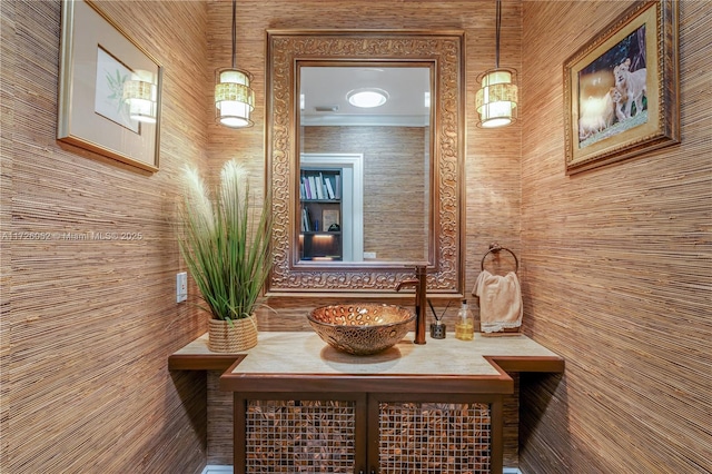 interior space featuring wood walls, ornamental molding, and vanity