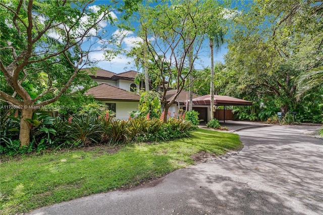 view of front facade with a front yard, a garage, and a carport