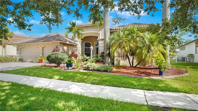 mediterranean / spanish house featuring a garage and a front lawn