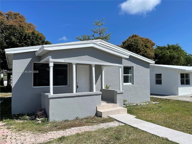 view of front of home with covered porch and a front lawn