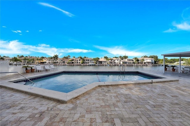 view of swimming pool featuring a patio and a water view