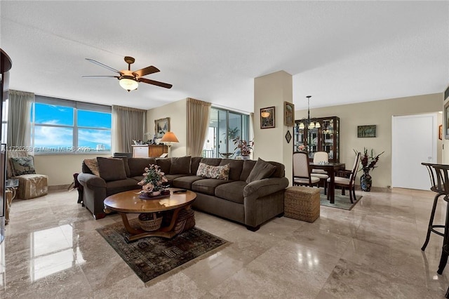 living room with a textured ceiling and ceiling fan with notable chandelier