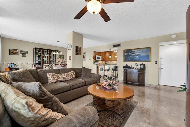 living room featuring a textured ceiling and ceiling fan