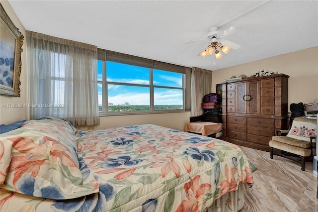 bedroom featuring multiple windows, a textured ceiling, and ceiling fan