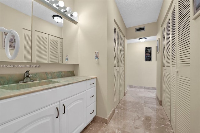 bathroom with a textured ceiling and vanity