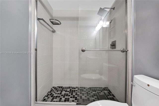 bathroom featuring toilet and an enclosed shower