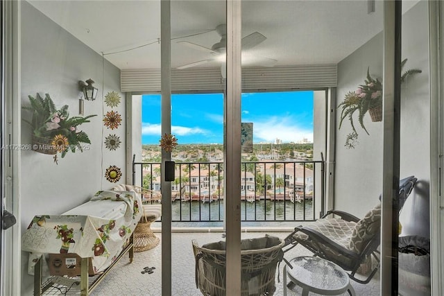 sunroom with ceiling fan, a healthy amount of sunlight, and a water view