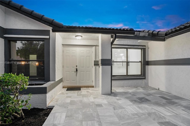 exterior entry at dusk with a patio area