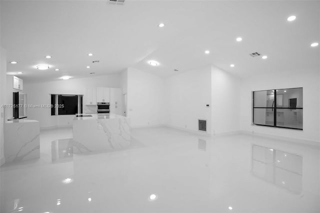 unfurnished living room featuring lofted ceiling