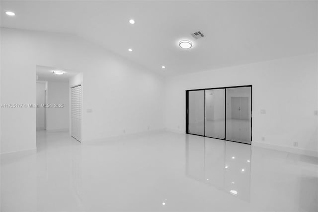 unfurnished room with vaulted ceiling