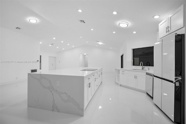 kitchen with white refrigerator, sink, white cabinets, a large island, and stainless steel dishwasher