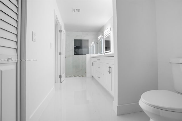 bathroom with toilet, a shower with door, vanity, and a wealth of natural light