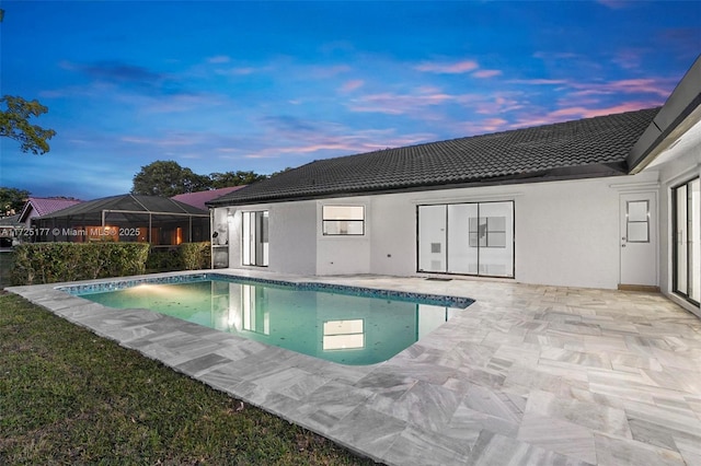 pool at dusk featuring a patio area