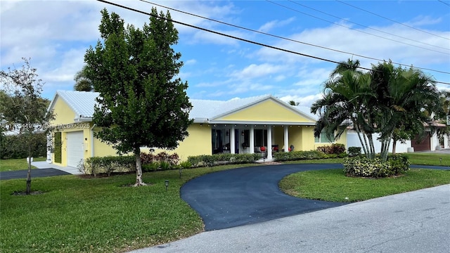 view of front facade featuring a garage, a porch, and a front yard