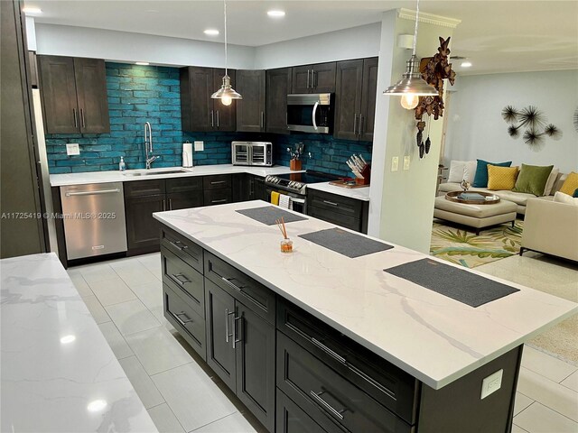 kitchen with stainless steel appliances, decorative backsplash, sink, and pendant lighting